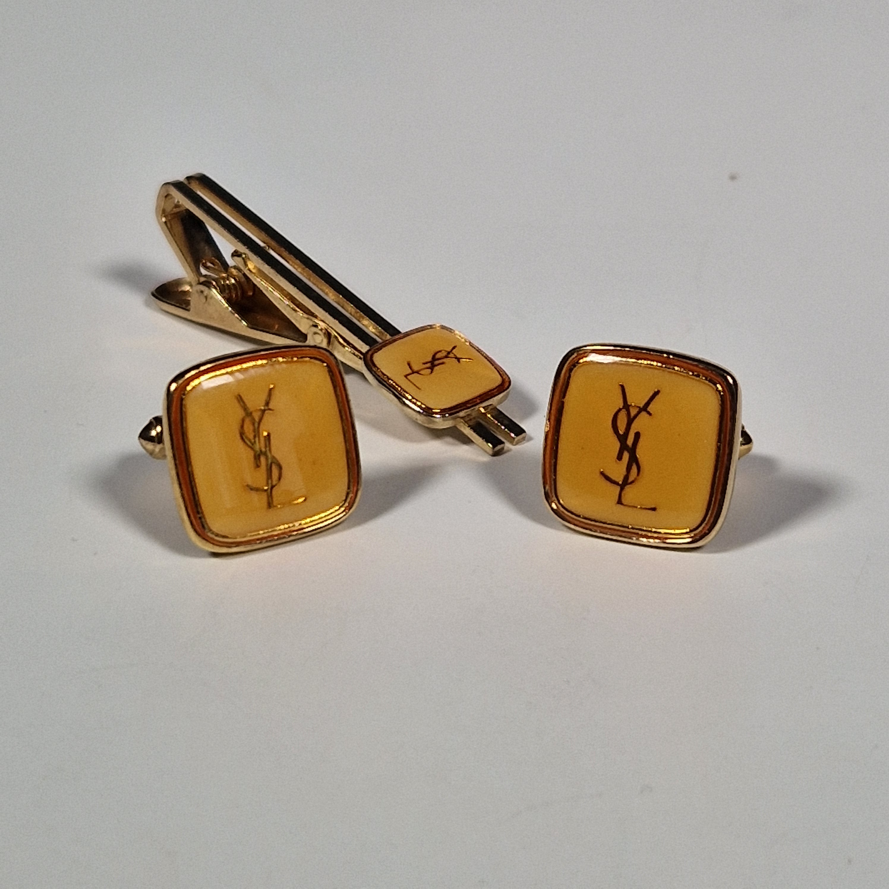 Yves Saint laurent a pair of cufflinks and a tie pin