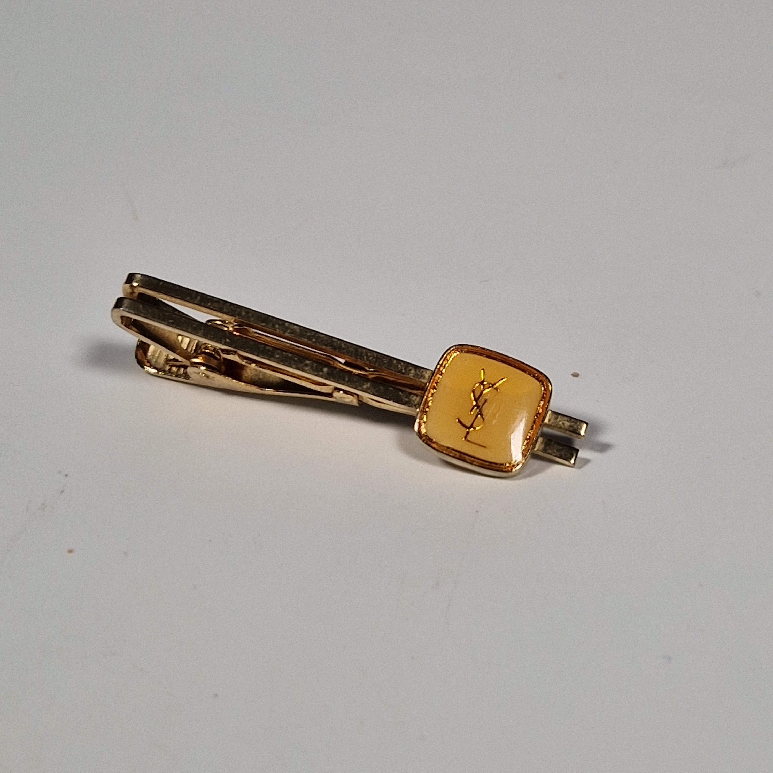 Yves Saint laurent a pair of cufflinks and a tie pin