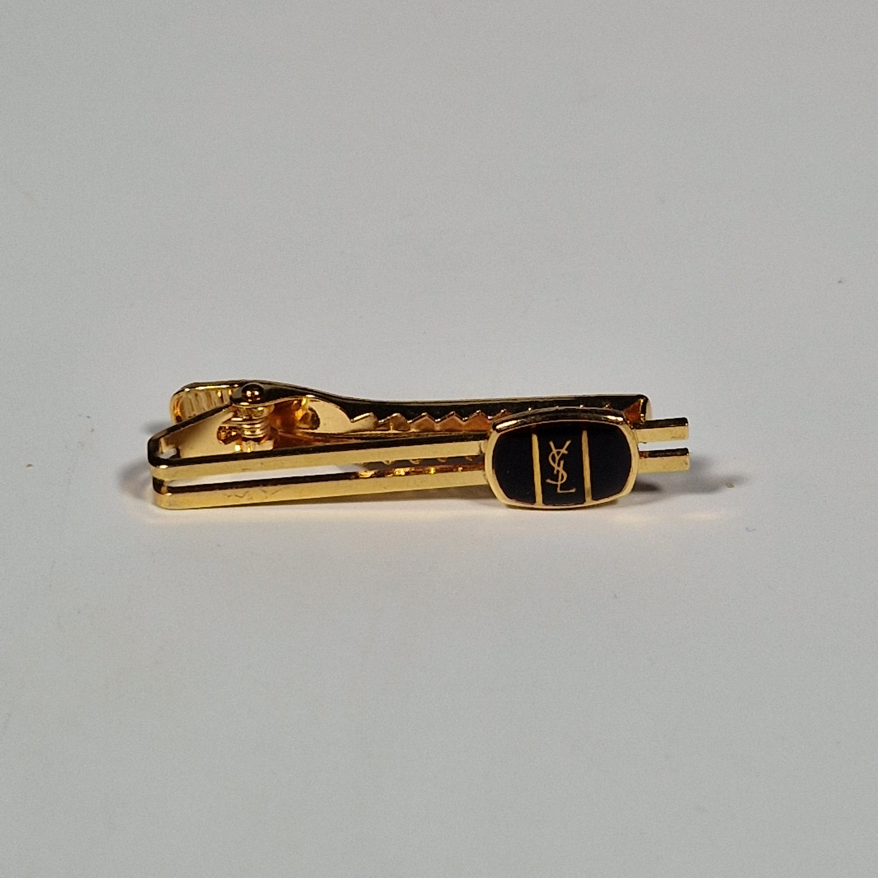 Yves Saint Laurent a pair of cufflinks and a tie pin